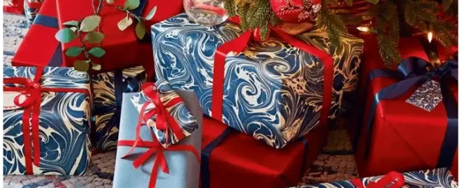 christmas presents sitting under the tree wrapped using the 2020 Pantone color of the year: classic blue