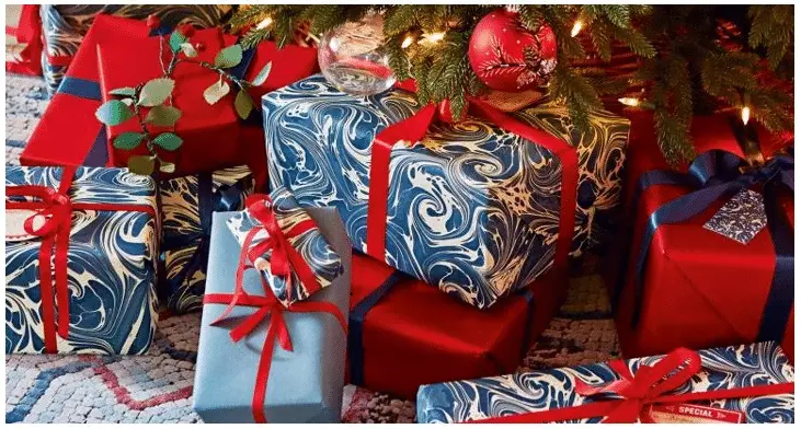 christmas presents sitting under the tree wrapped using the 2020 Pantone color of the year: classic blue