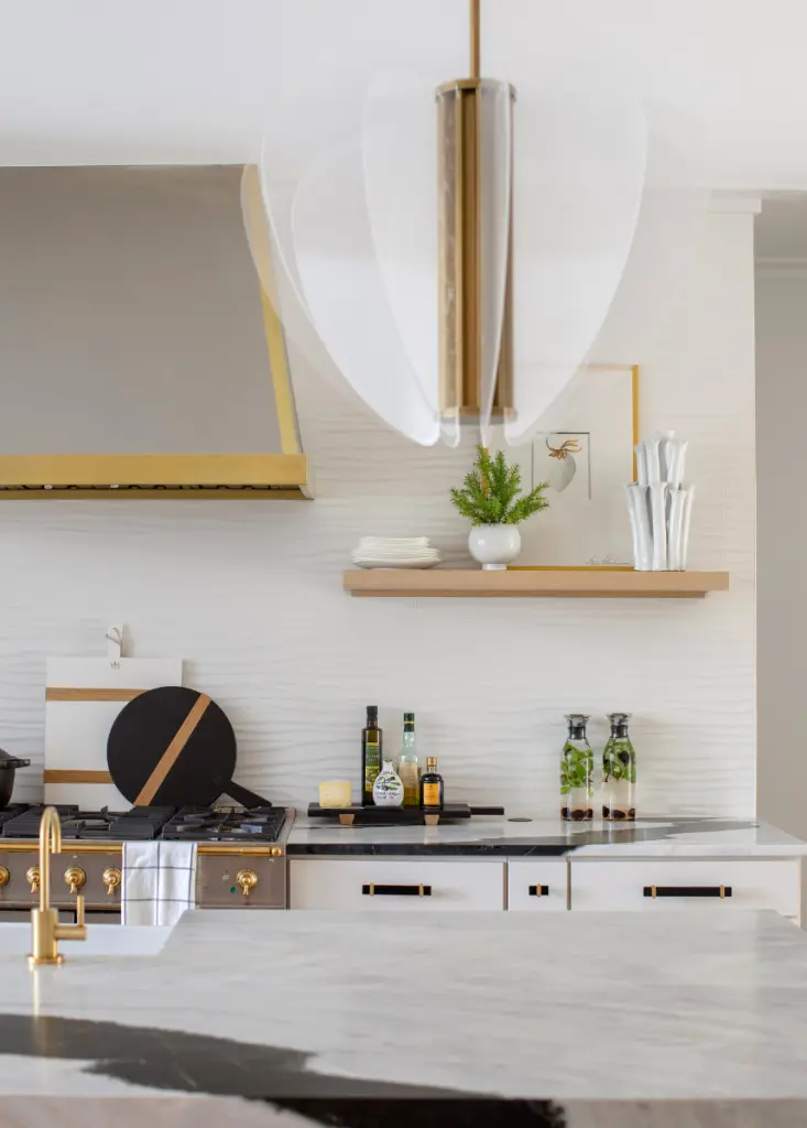 A black and white kitchen with strong gold accents for a bold modern look decorated by CHD Interiors.